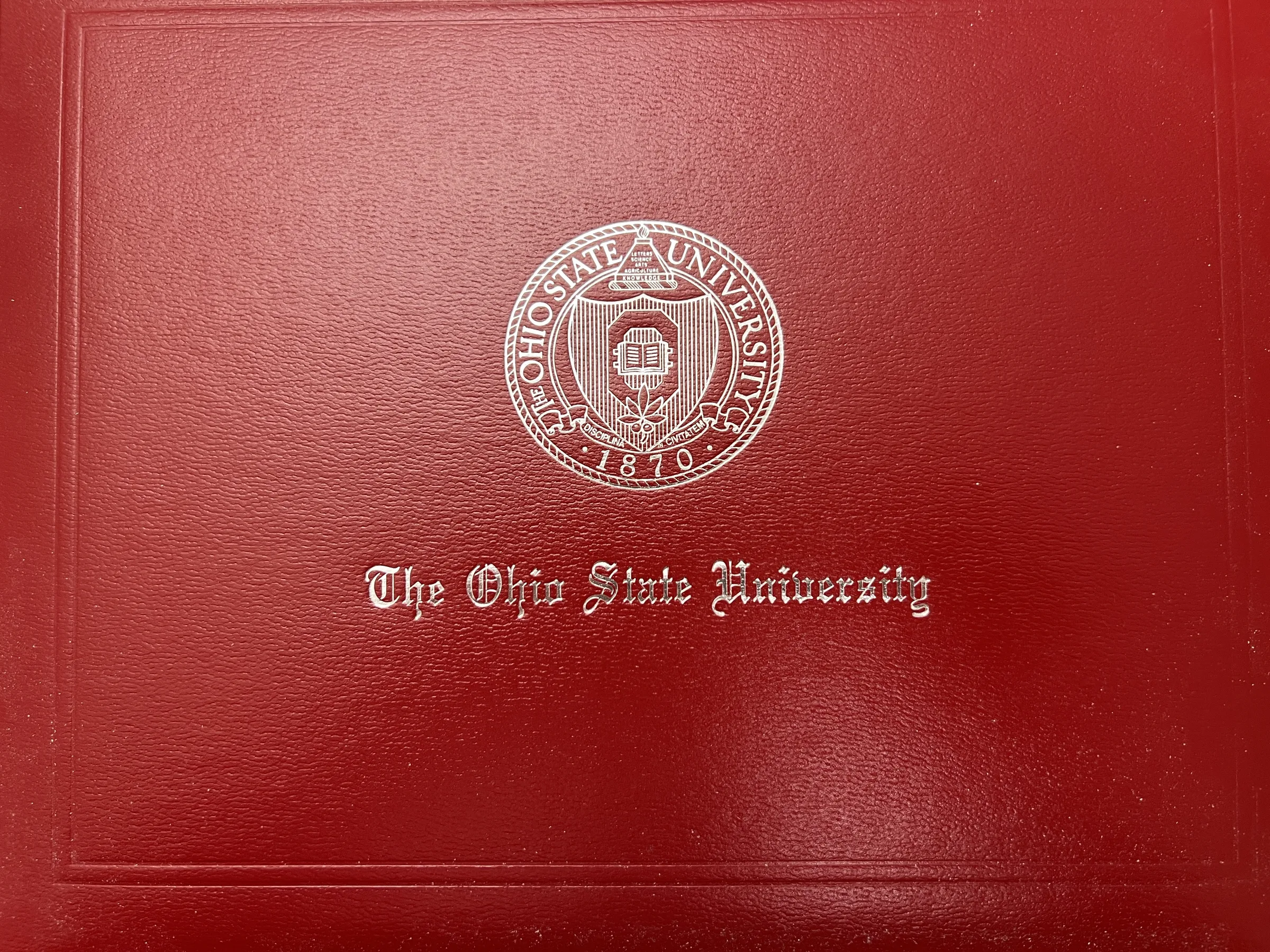A red leather diploma cover embossed with The Ohio State University seal.